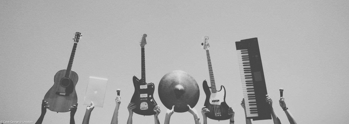 Musikinstrumente (Gitarren, Epiano, Schlaginstrumente) werden in die Höhe gehalten