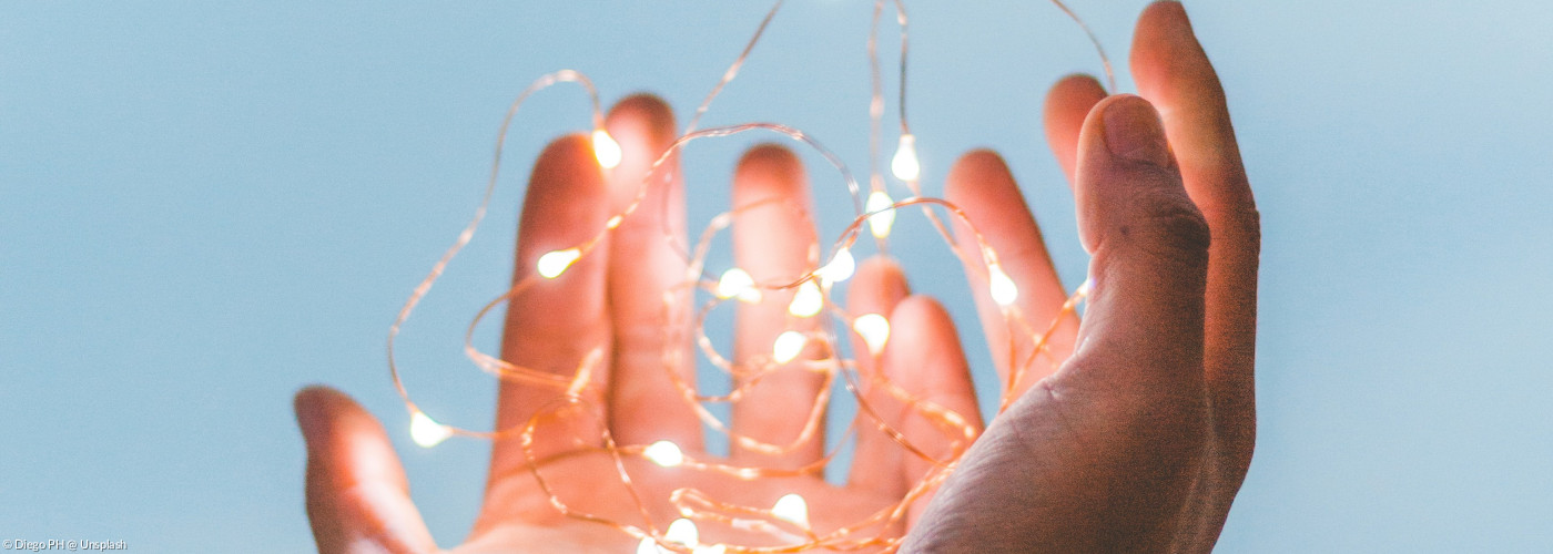 Hande halten eine filigrane Lichterkette
