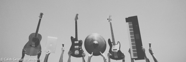 Musikinstrumente (Gitarren, Epiano, Schlaginstrumente) werden in die Höhe gehalten