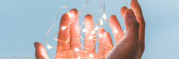 Hande halten eine filigrane Lichterkette