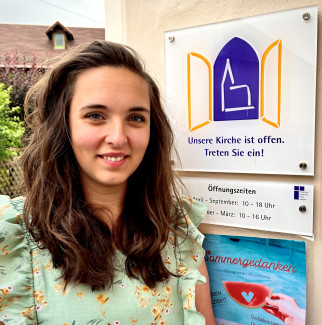 Pfarrerin Nicola Aller vor einem Schild der Offenen Kirche