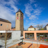 Ensemble aus verklinkerter Kirche und modernen flachen Anbauten