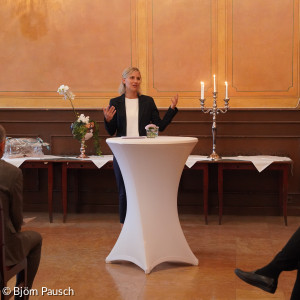 Frau spricht zu Anwesenden